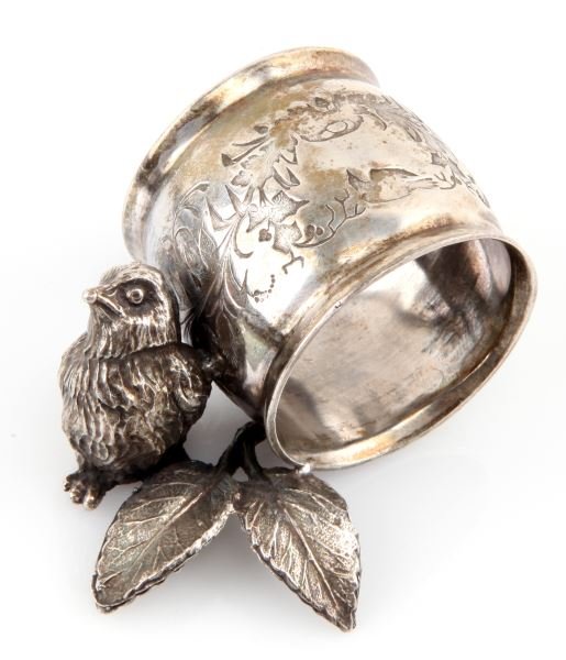 ANTIQUE FIGURAL SILVER PLATE NAPKIN RING: Antique figural napkin ring with a small bird and leaves. There are no apparent maker's mark or hallmarks. A small bird next to leaves holds up the ornately engraved ring. Very good condition.