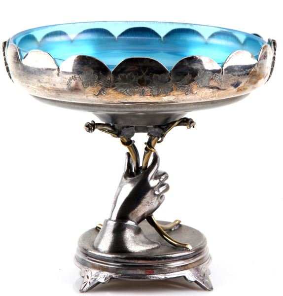 WILCOX SILVERPLATE CO. 864 CENTERPIECE: 8.5 inch tall and 9.5 inches across bowl. Footed base with right hand extended upwards holding four golden "stems" that support bowl. Applied leaves under and at waist of bowl. Inside of bowl is chase