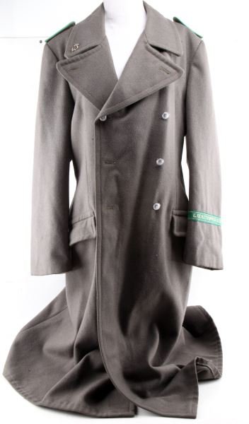 COLD WAR GDR GRENZTRUPPEN UNIFORM VETERAN INSIGNIA: Cold War East German Grenztruppen uniform coat with swastika veteran's insignia on the right collar. Green piping on shoulder boards. Inside tag reads "g48." Eight buttons. Internal pocket on left sid