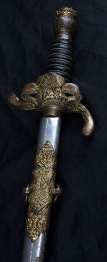 LAMB LION PEACE OR WAR FRATERNAL SWORD W SCABBARD: Odd Eye Lamb Lion fraternal sword with scabbard. 28 inch blade has the name "William G. Hutchings." Reverse side has Lamb Lion emblem with the phrase "Pax Aut Bellum" along with the mark of the manufa
