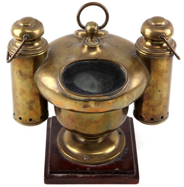 ANTIQUE BRASS MARINE BINNACLE COMPASS WITH 2 LAMPS: Antique brass binnacle compass with dual oil lamps. The brass enclosure is placed on a wooden base. Lid is engraced "WILLAMENA". Dual view holes, one round and one oval shaped, both with glass intact.
