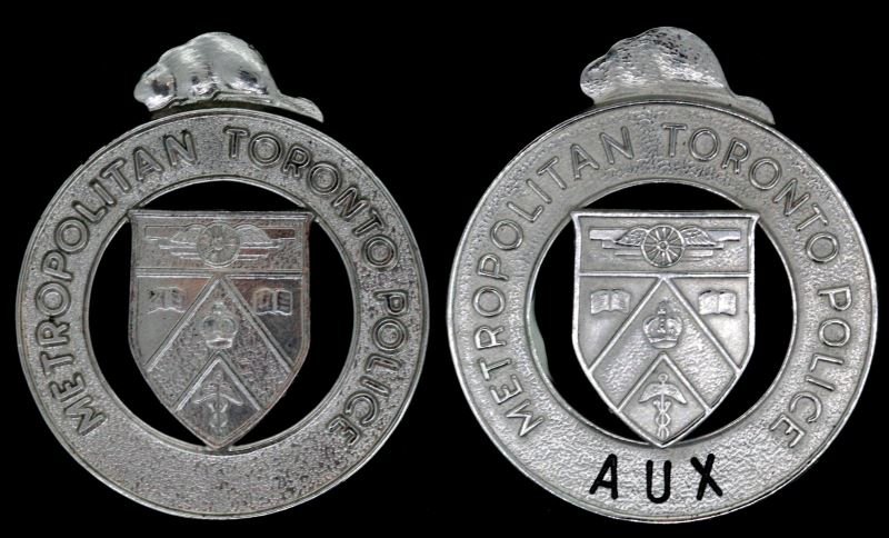 METROPOLITAN TORONTO POLICE CAP BADGE LOT OF 2: One is Auxiliary and this one is Boyd Boyd maker marked while the other is not, each has screw backs and are very good and complete. This lot has a reserve