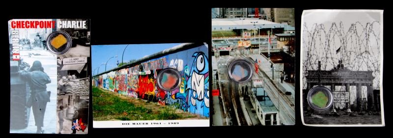 4 POSTCARDS WITH BITS OF THE BERLIN WALL: Four unused postcards with bits of the Berlin Wall in little clear plastic holders: Die Mauer 1961-1989, two Checkpoint Charlie, and a Brandenburger Tor postcard. Postcards have some bending and sligh