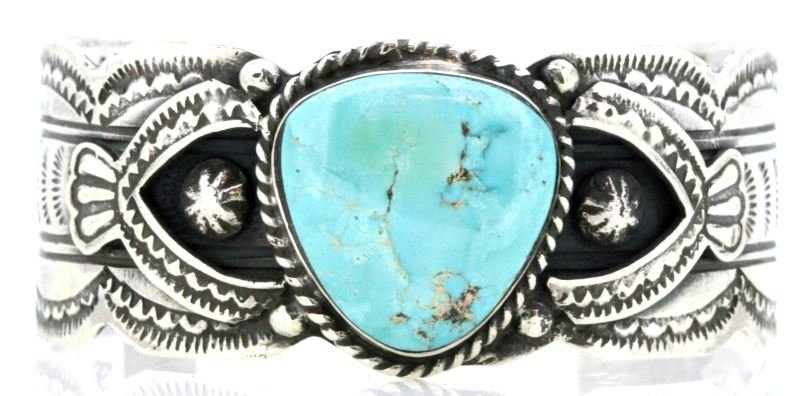 LADIES SOUTHWEST SILVER BRACELET WITH TURQUOISE: Very nice piece, fancy bracelet with seven different applications including fluting, hand tool stamping, plus triangular cabochon turquoise, bezel set in center. 28mm at widest point.