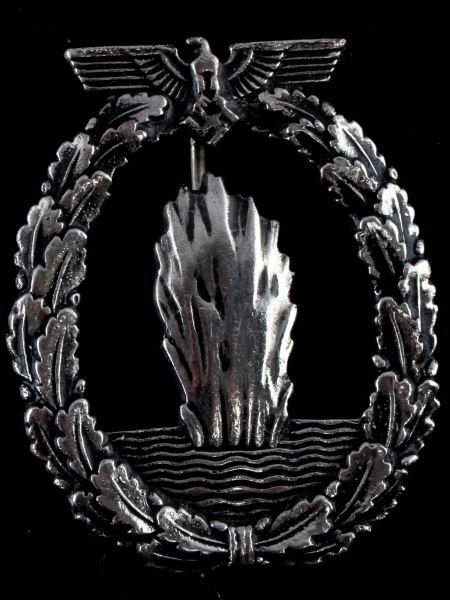 WWII GERMAN THIRD REICH MINESWEEPER BADGE: A Third Reich minesweeper badge. Features a water funnel surrounded by an oak leaf wreath with a Reichsadler. In very good condition. Unauthenticated.