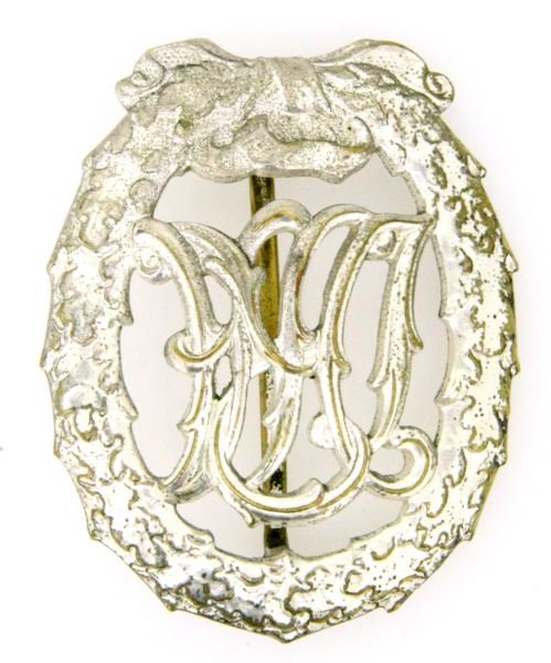 GERMAN FIRST MODEL DRA SPORTS BADGE IN SILVER: A German DRA sports medal in silver. Rear has DGRM 35268 patent mark and H. Wernstein Jena-Lobstedt maker's mark. Rear flat pin with "C" clasp and 180 degree lie. In very good condition with most of i