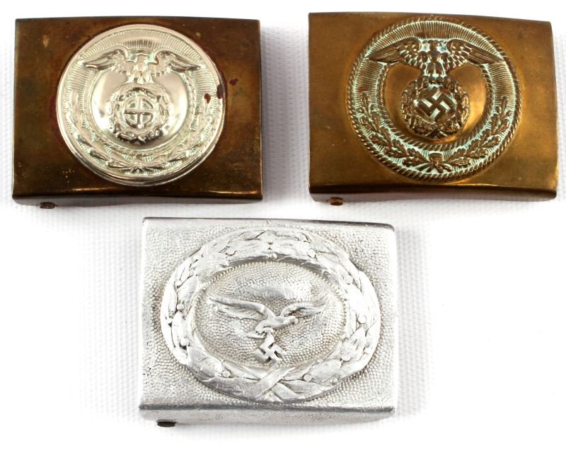 LOT OF THREE WWII THIRD REICH EM BELT BUCKLES SA: A lot containing three Third Reich enlisted men's belt buckles. Includes two SA belt buckles, one with round swastika and another with a squared mobile swastika. Also includes one Luftwaffe belt buckl