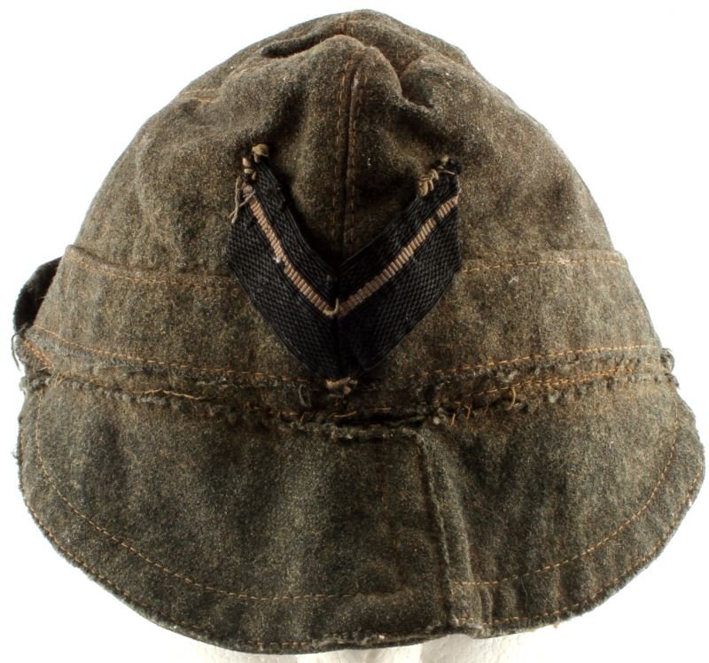 WWII ITALIAN FASCIST BUSTINA TROPICAL CAP AXIS: Italian tropical field cap, as used by Axis Powers during WWII. Features a flip-up visor and ear flaps. Has a black "V" shaped insignia with a single line. Wooden buttons. In very good condition with 