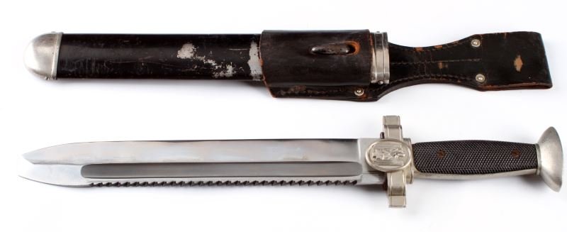 WWII THIRD REICH RED CROSS EM HEWER WITH FROG: German WWII Red Cross hewer with scabbard and frog. Blade is in excellent condition, measures 10.5 inches, and only shows very slight signs of wear. The mark of the manufacturer--GES Geschützt--appea