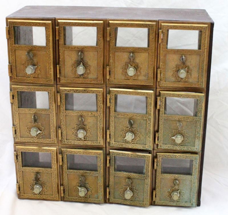 1957 CORBIN 12 UNIT POST OFFICE BOX W BRASS DOORS: 1957 Corbin made 12-unit post office box. Painted wood construction with brass and glass doors. Alphabet dials and key hold above. Some verdigris evident. Overall good vintage condition.