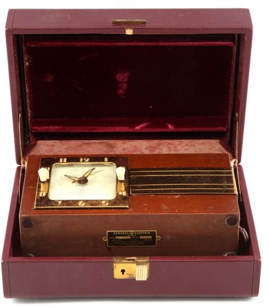 GENERAL ELECTRIC DOUBLE CLOCK 75 YEAR EDITION: A wood encased double sided alarm clock from General Electric. Both sides have alarm functions and one side has "AID" stamped into it. The clock is in good condition but it is untested due to the stat