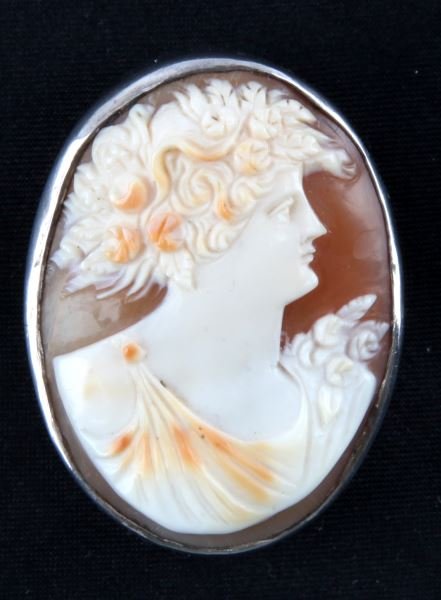 LADIES VINTAGE SHELL CAMEO SET IN STERLING SILVER: Oval shape, measuring 35 x 27mm, very high bezel setting containing oval shape shell cameo, rose motif, in very good condition.