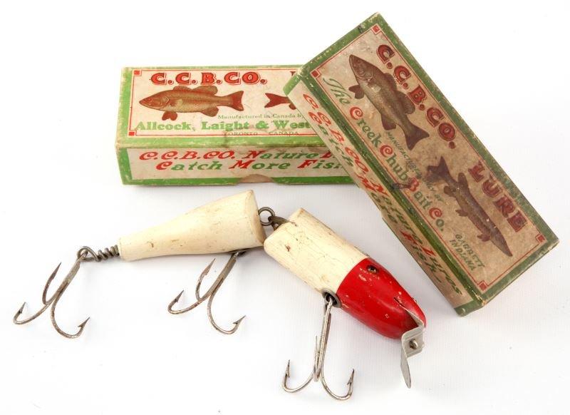 2 FISHING REEL BOXES & 1 SALT WATER JOINTED PIKIE: One Creek Chub box, one Allcock, Laight & Westwood box, and one salt water jointed pickie lure. Boxes empty. Expected signs of age and wear.