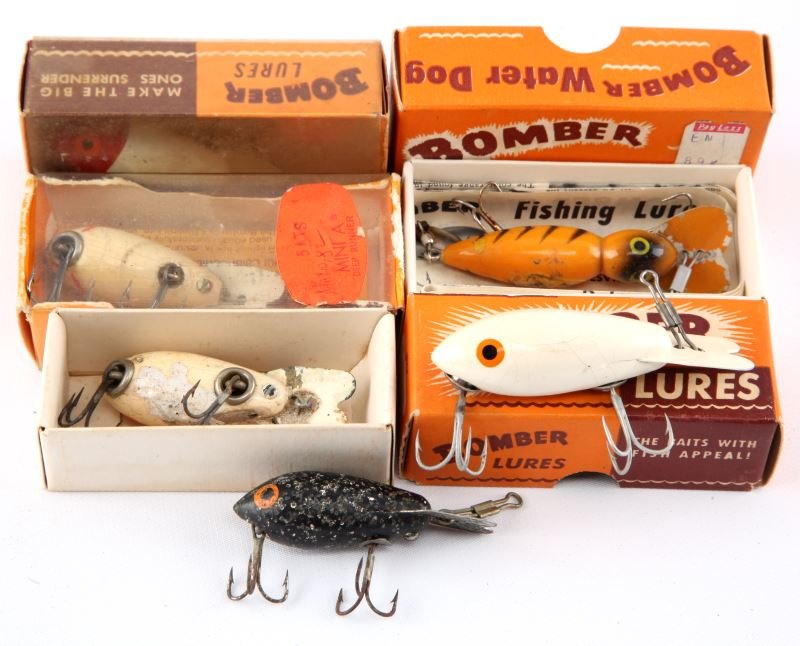 4 BOMBER BOXES WITH LURES & 2 SMALL BOMBER LURES: Four Bomber boxes with lures and two small Bomber lures. Expected signs of age and wear.