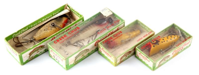 FOUR CREEK CHUB BOXES WITH LURES: Four Creek Chub boxes with lures. Two medium and two small. Expected signs of age and wear.