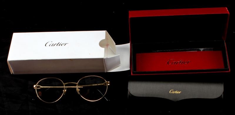 CARTIER 140 EYEGLASSES WITH CASE BOOKLET AND BOX: Inner arms are marked "Cartier Paris 140" and "140 made in France CE". Nose is marked "50, square, 20". Includes leather case with magnetic closure. Some light scratches present to frame; overall in v