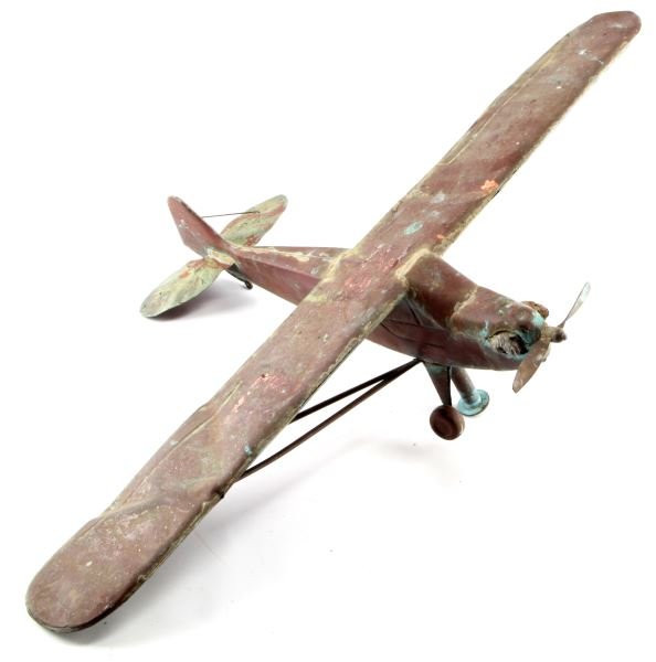 VINTAGE MID 20TH C. COPPER AIRPLANE WEATHERVANE: A sheet copper airplane weathervane. Its original red finish has worn away in places and the copper has developed a rich green patina. Has rotating propeller and engine details. One wheel and wing str