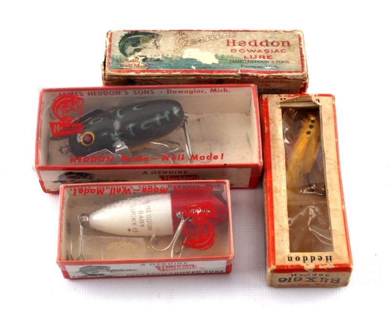 4 VINTAGE HEDDON BOXES WITH FISHING LURES: Four vintage Heddon boxes with lures: One box with window and lure, one box with Crazy Crawler, one box with Spoon circa 1928, and one box with Lucky 13 lure. Expected signs of age and wear.