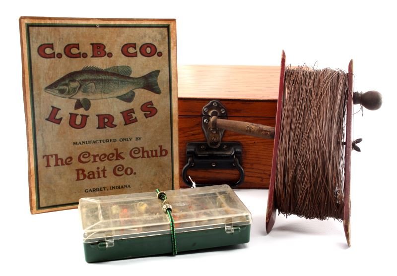 WOODEN FISHING BOX W CCB AD WIRE & SMALL LURES: Wooden fishing box with a CCB Company advertisement, spool of wire, and a container of small lures. Expected signs of age and wear.