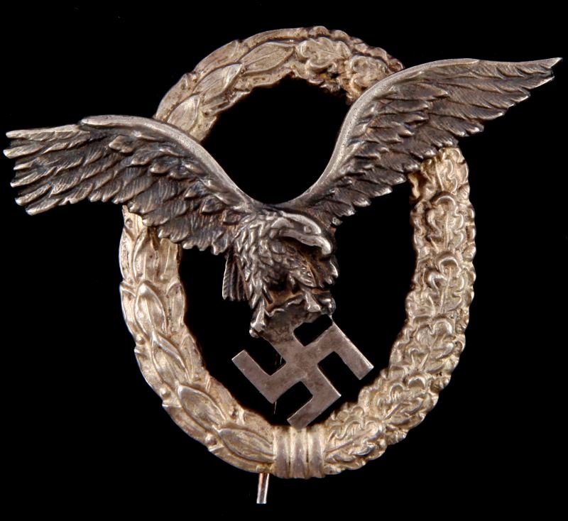WWII LUFTWAFFE THIRD REICH PILOT OBSERVER BADGE: Rear stickpin with 45 degree lie and "C" clasp. Marked with "C E Juncker, Berlin" maker's mark at rear. Two part construction; eagle is held in place by two rivets. Made of non ferrous metal. In very 