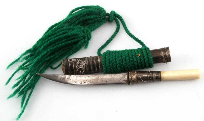 ANTIQUE IVORY HANDLED KNIFE W SILVER SCABBARD: Middle Eastern or North African knife with ivory and silver-wrapped grip and silver-wrapped niello scabbard. Overall length of knife 8.5 inches. In good condition with some wear.
