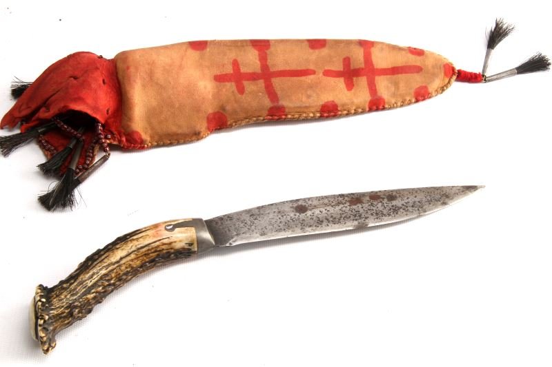 ANTIQUE STAG HANDLE HUNTING KNIFE WITH SHEATH: Has a 7.5 inch blade with a curved stag horn handle. Includes an ornate brown leather sheath decorated with red paint and beads. In good condition with some oxidation to blade.