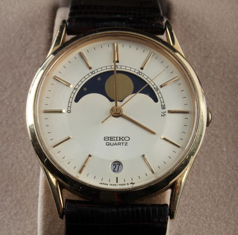 MENS SEIKO "MOONPHASE" QUARTZ WATCH WITH STRAP: Needs a battery; men's Seiko, model #7434, moon phase dial with date feature. Gold plate, steel back. Brown leather strap. Boxes included.