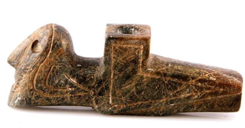 NATIVE AMERICAN HUMAN HEAD EFFIGY STONE PIPE: A 6.5 by 1 by 2.25 inch black steatite effigy pipe. Depicts a human head with an open mouth. In very good condition with some surface wear.