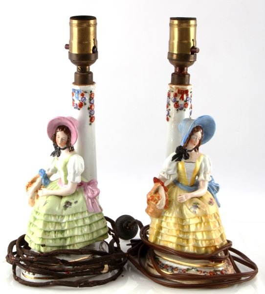 PAIR OF SITZENDORF GERMAN ANTIQUE PORCELAIN LAMPS: From the Alfred I. duPont estate, a pair of antique Sitzendorf German porcelain lamps, model 13104. Each features a sitting woman with a basket of flowers. Stands 11.5 inches tall. 660W Bryant socket,