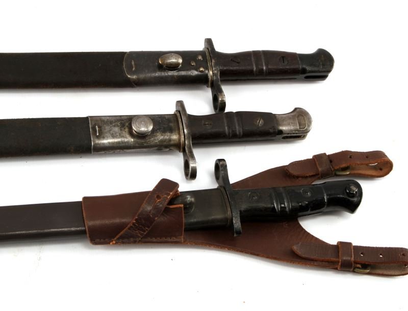 LOT OF 4 WWI REMINGTON BAYONETS 1907 1916 1913: One Remington 1907 bayonet, one 1916 bayonet, and two 1913 bayonets. All bayonets include leather sheath and one of the 1913 bayonets comes with a leather frog. All items are in good condition save fo