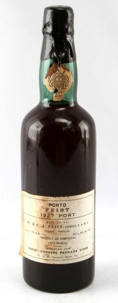VINTAGE 1927 PORTO FEIST PORT WINE NECK ULLAGE: Vintage 1927 Porto Fiest bottled in 1973, red wine. Label and seal still present. Low neck ullage. Red amber color. The label is stained, but overall good condition. Tight wax sealed cork. 1 pint and 