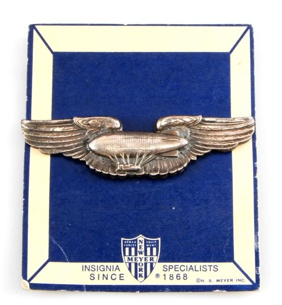 WWII AMERICAN USA AIR FORCE AIR SHIP PILOT WING: Measures 3 3/16 inches wide by 7/8 of an inch tall. The reverse is marked "NS MEYER INC. STERLING". Has a thin horizontal pin back. Mounted on original issue card.