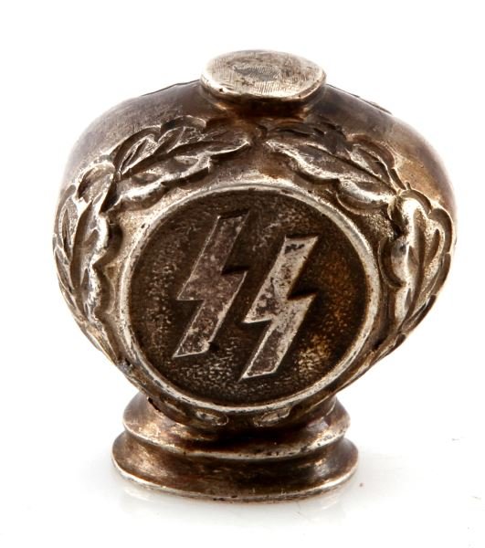 UNFINISHED SS DRESS DAGGER POMMEL: Unfinished SS dress dagger pommel. The pommel has Sig runes surrounded by oak leaves. The interior has a loose piece. 1.25 inches wide by 1.25 inches tall. This lot has a reserve.