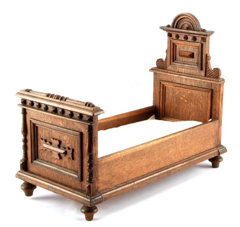 ANTIQUE VICTORIAN MAHOGANY DOLL BED W MATTRESS: Victorian-era Mahogany doll bed with original mattress. The bed has geometric carvings. Very good condition. No maker's mark. Measures 16.5 inches long by 8.25 inches wide and 13.5 inches tall. This l