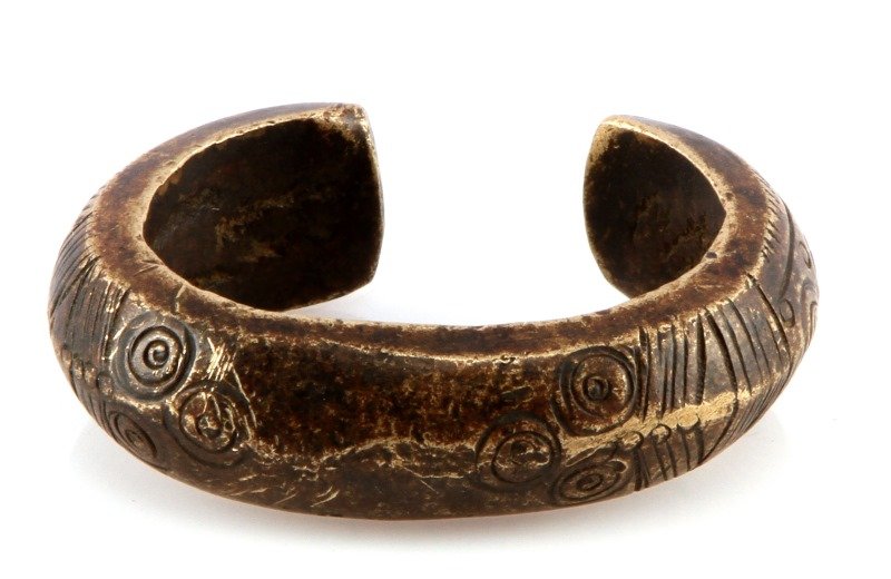 ANTIQUE BRONZE AFRICAN TRIBAL BRACELET: Small antique African bronze cuff bracelet with hammered geometric designs. Measures 1 inch tall by 3 inches wide.