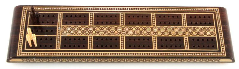 ROSEWOOD AND BONE VINTAGE CRIBBAGE BOARD: Vintage wood and bone cribbage board with all six pieces. The board has geometric inlaid pieces of bone and abalone. The board measures 11.5 inches by 3 inches. The inlay has some minor damage, howeve