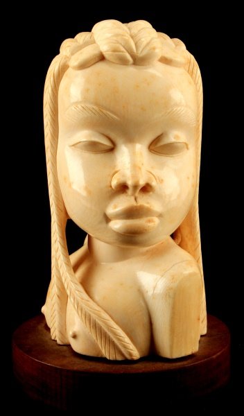 AFRICAN IVORY BUST CARVING OF YOUNG WOMAN 9" TALL: Pre-ban ivory nude bust depicting a young African woman. The woman portrayed has an intricate braided hairstyle This is an unsigned African carving measuring 9 inches tall including its wooden base. T
