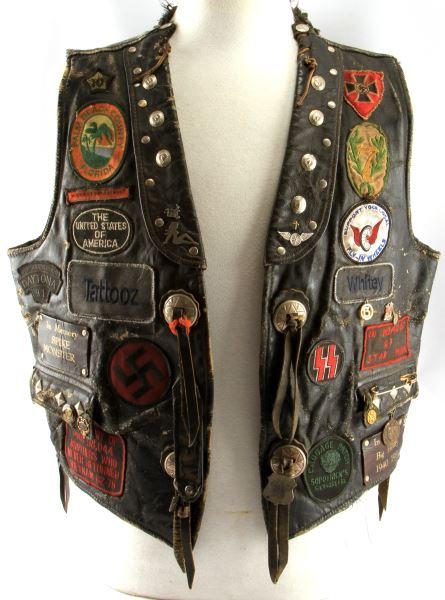 LEATHER BIKERS CUT VEST W/ STUDS & COLOR PATCHES: Leather club cut vest, with various memorial patches, plus colors and event patches and tokens. Varied pins and other accoutrements. To be used with respect to club. In very good condition.This lot ha