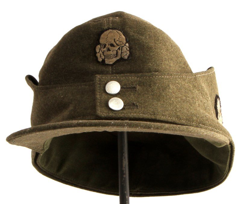 WWII GERMAN SS M43 TOTENKOPF ENLISTED MENS CAP: WWII German Third Reich M43 field cap in feldgrau wool with Bevo SS and Totenkopf insignia. The SS eagle has some wear and discoloration. All machine sewn. The buttons have no makers mark. Green twill