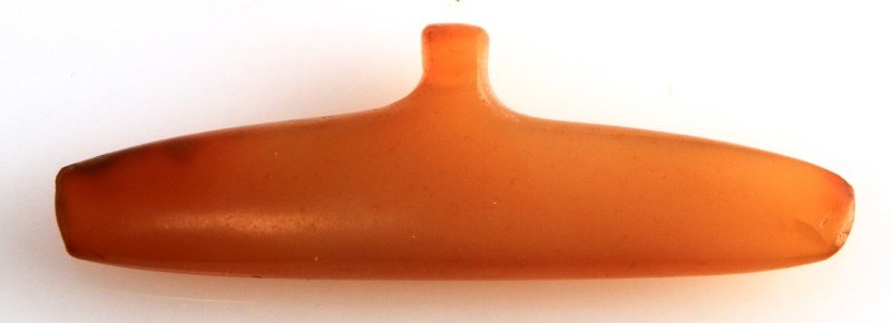 NATIVE AMERICAN CARVED STONE DRILLED GORGET: A carved stone gorget with perforation for stringing. Likely carved out of olive opal. Measures 2.5 inches wide and 7/8 of an inch in height. In very good condition and free of damage.