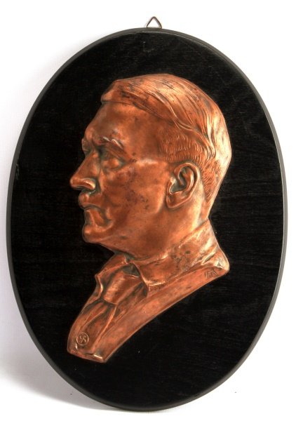 ADOLF HITLER COPPER PLAQUE ON WOOD 12.5 INCHES: WWII-era Adolf Hitler wall plaque. The ebony colored oval has a cooper profile bust of Third Reich Germany's leader. The copper bust measures 9 inches tall while the item as a whole measures 12.5 inch