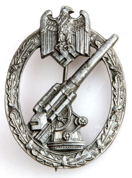 WWII THIRD REICH GERMAN ARMY ARTILLERY FLAK BADGE: An artillery flak badge with silver wash. No maker's mark. The rear is fitted with a stickpin on a barrel hinge with rounded "C" retainer and has 180 degree pin lie. In very good condition. Includes p