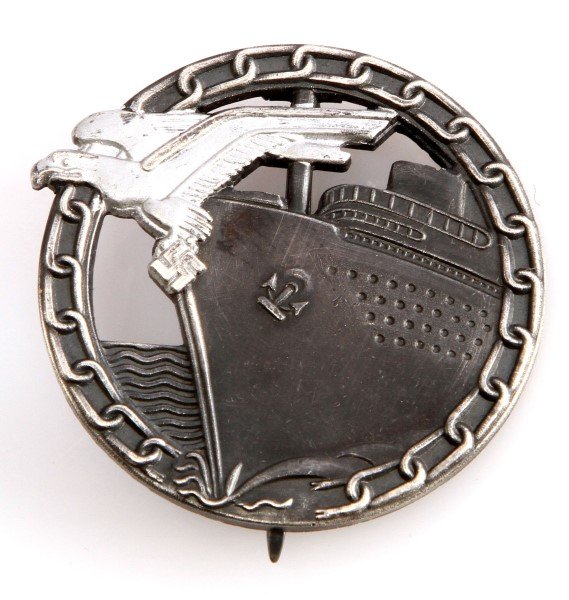 WWII THIRD REICH NAVAL BLOCKADE RUNNER BADGE: German World War II Naval Blockade Runner Badge. The reverse side is maker marked ‘Fec Otto Placzek Berlin Ausf Schwerin Berlin’. Has a wide vertical pin back. Very fine condition. Uneuthenticated