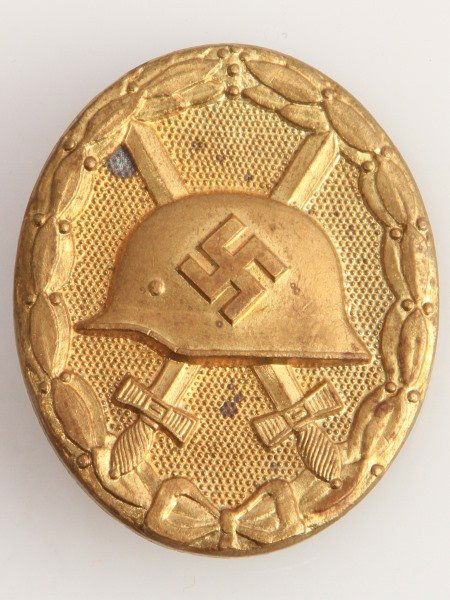 WWII GERMAN THIRD REICH GOLD WOUND BADGE: German World War II gold wound badge. The reverse side is marked ‘L/63’. Has a "coke bottle" pin back with "c" catch. Solid back. Some corrosion but overall good condition. Measures 1.75 inches ta