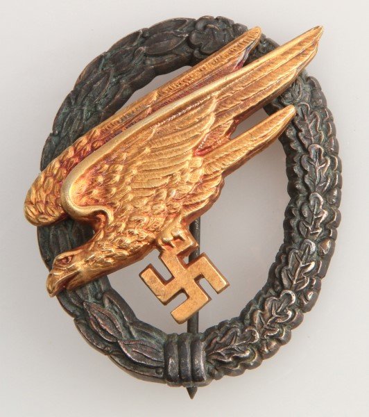 WWII THIRD REICH LUFTWAFFE PARATROOPER BADGE: German World War II Luftwaffe Paratrooper Fallschirmjager Jump Badge. The reverse side is maker marked ‘G H Osang Dresden’. Has a thin vertical ‘T’ bar style pin back. Two piece two domed rive