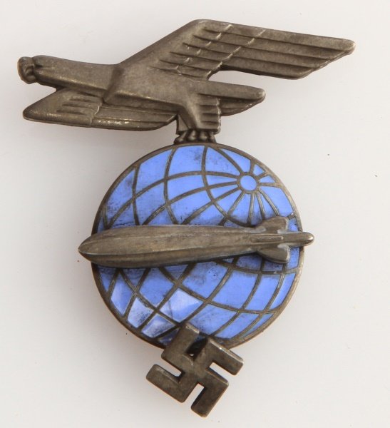 GERMAN WWII ZEPPELIN AIR SHIP VISOR CAP BADGE: German World War II Zeppelin Air Ship Visor Cap Badge. Measures 1-1/2" wide by 1-3/4" tall. There are three flat prongs on the reverse side for securing them to the visor hat. Three piece nickel const