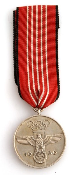 WWII GERMAN 1936 BERLIN SUMMER OLYMPICS DECORATION: German World War II 1936 Summer Olympics Decoration. Includes the issue ribbon with a thin horizontal pin back. Nickel construction. Unauthenticated, sold as is.