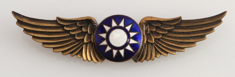 WWII USAF FLYING TIGERS CHINESE PILOT WINGS BADGE: USAAF World War II Flying Tiger Chinese Pilot wings. Measures 2 11/16” wide by 5/8” tall. The reverse side is numbered ‘551’ and has Chinese characters on the back. Has a thin horizontal pin b