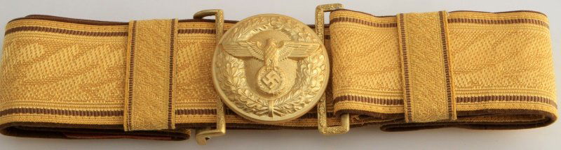 GERMAN WW2 POLITICAL LEADER BROCADE BELT PL BUCKLE: German World War II Political Leader Brocade Belt with a special PL Belt Buckle. The buckle measures 2" in diameter and is maker marked 'RZM M4/24'. The gold brocade belt measures 34" long by 1 15/16"