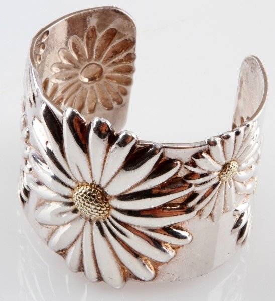 TIFFANY &CO LARGE DAISY CUFF BRACELET 925&18K GOLD: Sterling silver and 18kt gold cuff bracelet by Tiffany & Co with daisies. Each has 18kt solid gold seed head at its center. The interior is marked 2003/ Tiffany & Co./925/750. This open cuff can be sl